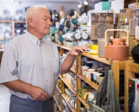 Senior man choosing variety goods for kitchenの写真素材