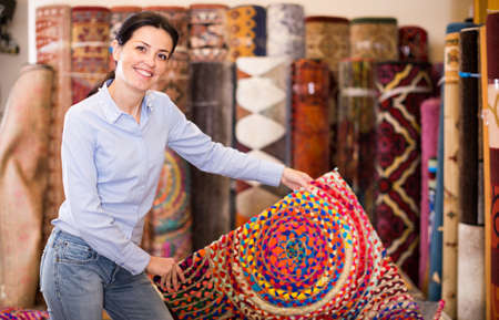 Adult woman buyer choosing colour carpetsの写真素材