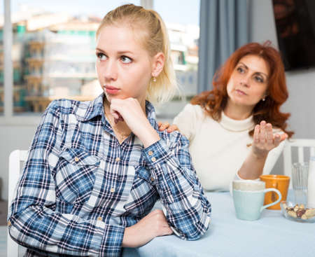 Mature mother soothes adult daughterの写真素材
