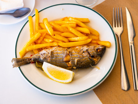 Whole roasted salema with crispy French fries and lemon