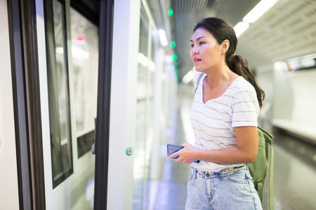 Woman getting on train in subway station