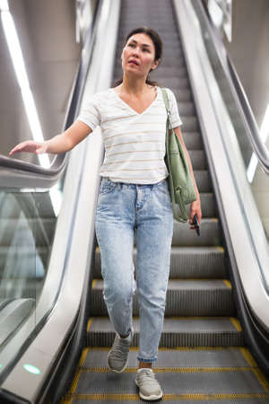 Woman going through escalatorの写真素材