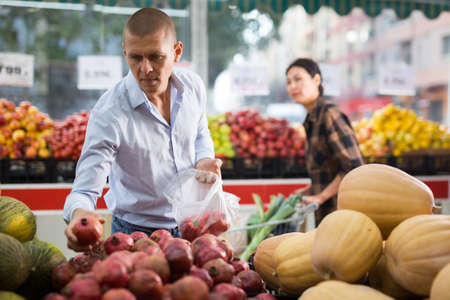 Man and woman choosing goods in greengrocerの写真素材
