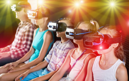 Family of five is watching VR together in the room.