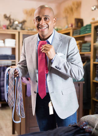 Man choosing new tie in clothing boutiqueの写真素材