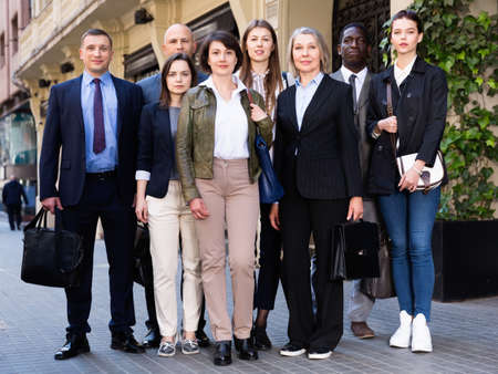 Portrait of successful business people of different ages and nationalities standing together on city streetの写真素材