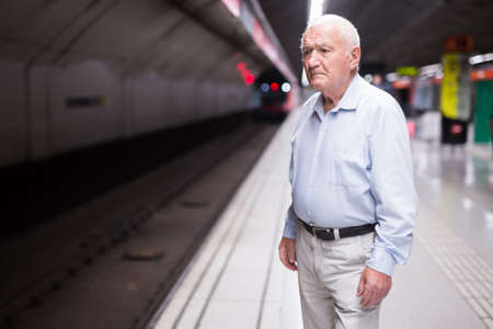Senior man waiting in subway stationの写真素材