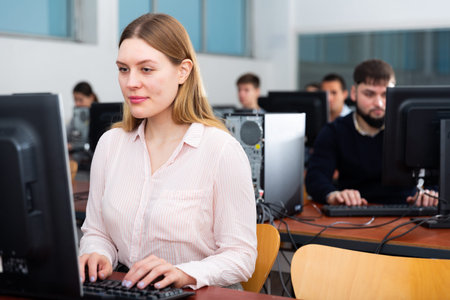 Group of people of different ages learning to use computers in classroomの写真素材