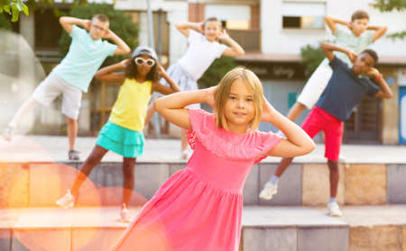 Smiling tween girl street dancer posing during performance with groupの写真素材