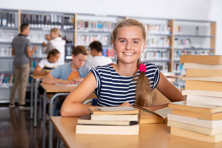 Girl reading books in college libraryの写真素材