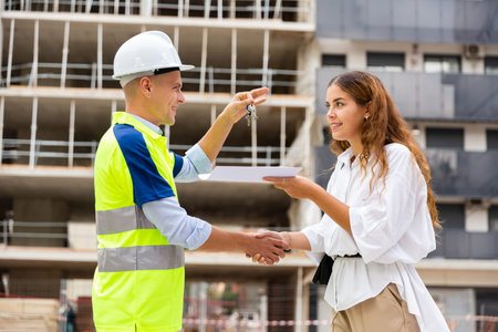 Woman getting keys to new apartment from enginner