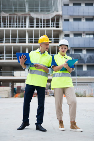 Two architects with laptop discussing construction plan
