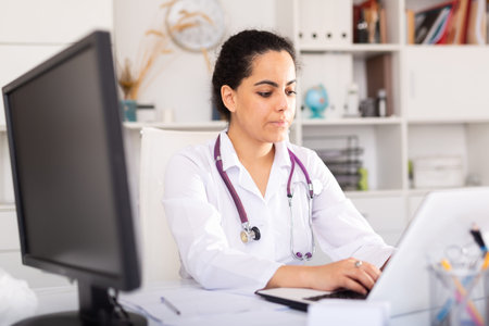 Female doctor working on laptop in office