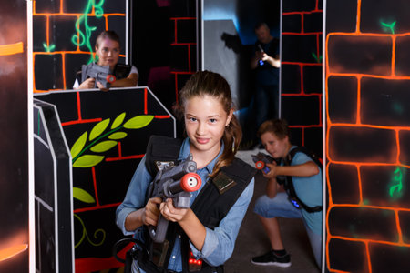 Positive girl aiming laser gun at other playersの写真素材