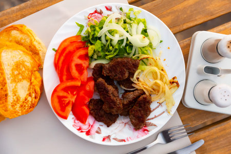 Traditional Turkish kofte prepared on mangal with vegetables