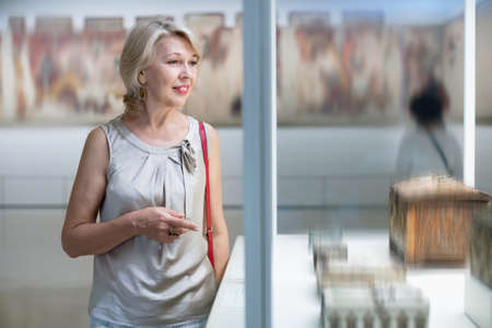 Adult female looking at artwork copper exhibit in the gallery indoorsの写真素材