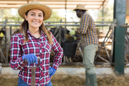Latino american female farmer standing at the cow farm