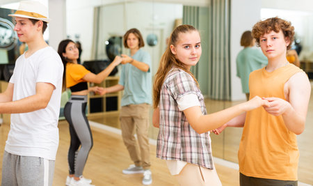 Teenagers dancing in pairs slow ballroom dances in choreography class