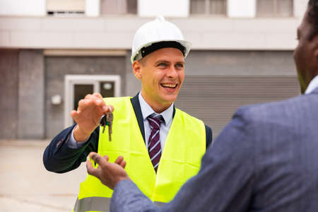 Engineer giving keys to new apartment to manの写真素材