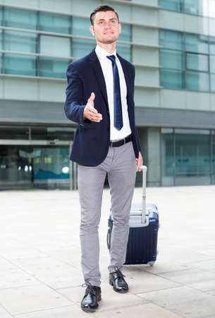 Adult man in suit with suitcase is meeting his partnerの写真素材
