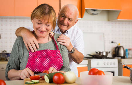 Happy aged couple cookingの写真素材