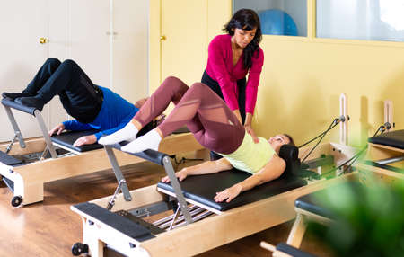 Female pilates trainer helping pilates woman during trainingの写真素材