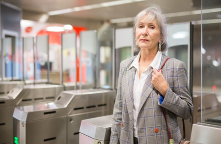 Senior woman at entrance to subway station