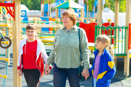Two young girls walking with their grandmother