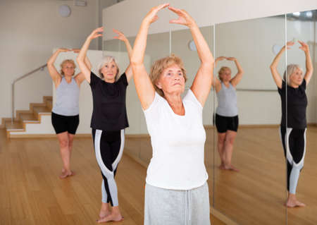 Elderly woman practicing ballet dance moves in choreographic studioの写真素材