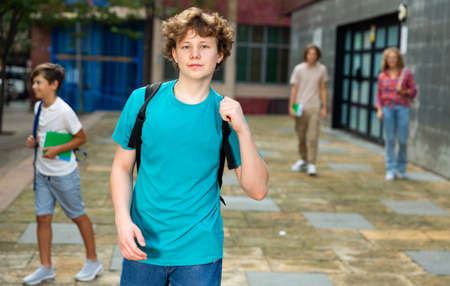 Teen boy walk along summer street after finishing college lessonsの写真素材