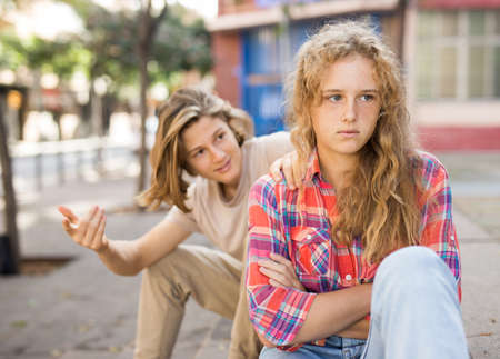 Sad teenager girl sitting on steps outside schoolの写真素材