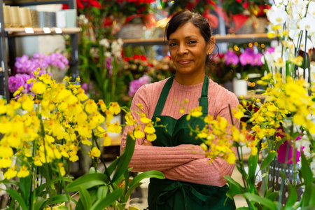 Portrait of latino woman owner flower shop with potted plants in her handsの写真素材