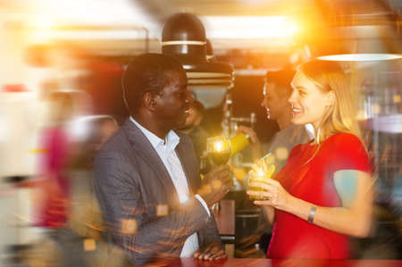 Cheerful african american man flirting with girl on partyの写真素材