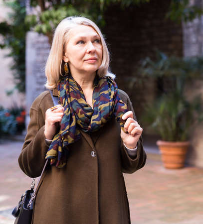 Portrait of an elegant elderly woman on spring street of european cityの写真素材