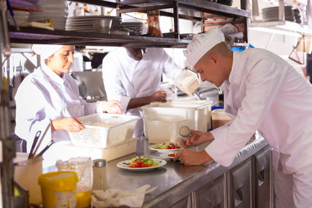 portrait of happy male cook cooking dishes in restaurante