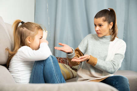 Woman having communication conflict with small daughter cryingの写真素材