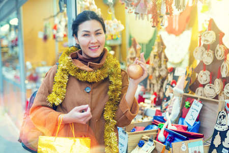 Woman choosing christmas decorations at fairの写真素材