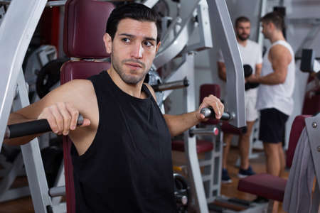 Man on power exercise machine in gymの写真素材