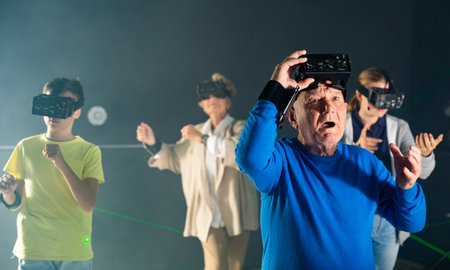 Astonished old man playing VR games with his familyの写真素材