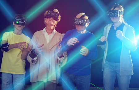 Grandparents with grandchildren in virtual reality glasses in quest roomの写真素材