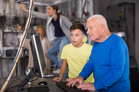 Teenager together with grandfather looking for puzzle solution in quest room