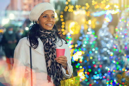 Positive hispanic woman at christmas fairの写真素材