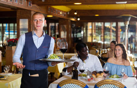 Portrait of confident waiter working at restaurantの写真素材