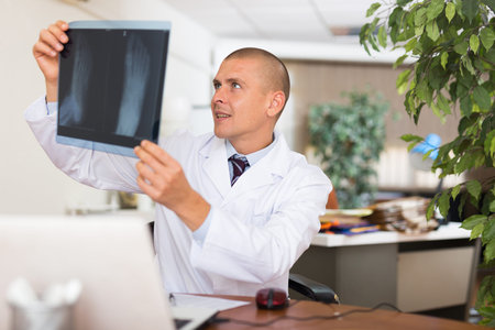 Man doctor analyzing roentgenogram in his office