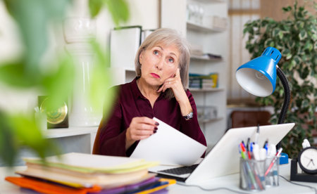 Upset woman with documents in company at modern workplace