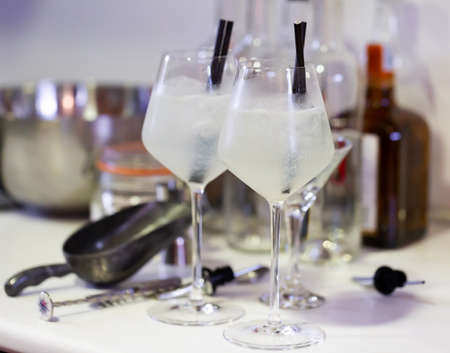 Cold cocktail with ice gin and tonic in glass goblets with strawsの写真素材