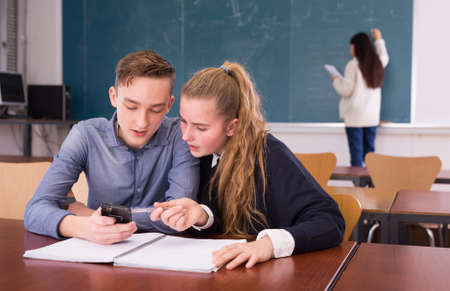Female and male students writing notes togetherの写真素材