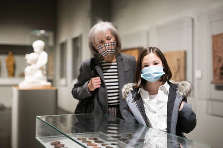 Inquisitive preteen girl in protective mask visiting historical museumの写真素材