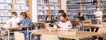 Teenagers in masks spending time in library