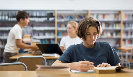 Boy preparing for exams in libraryの写真素材